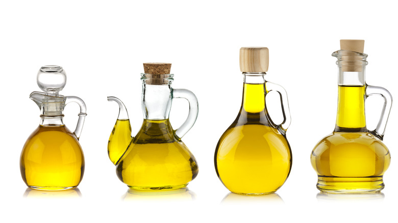 Several bottles of olive oil against a white background