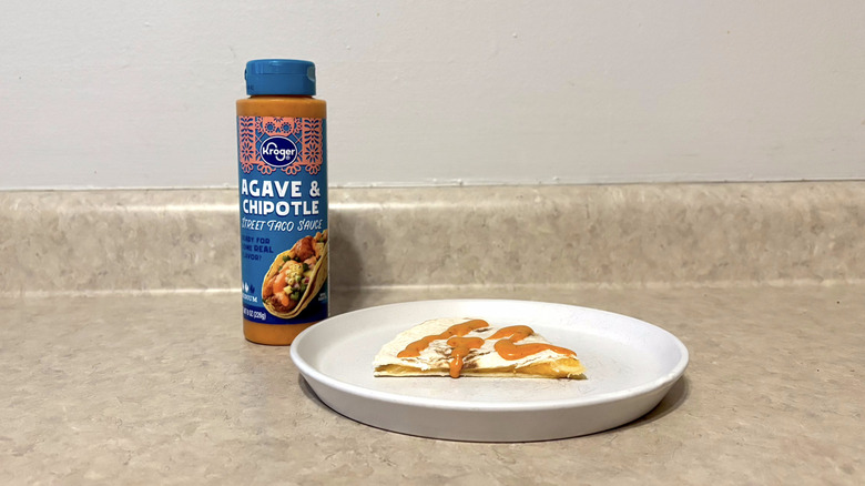 Kroger creamy agave & smoked chipotle taco sauce on quesadilla on white plate on countertop