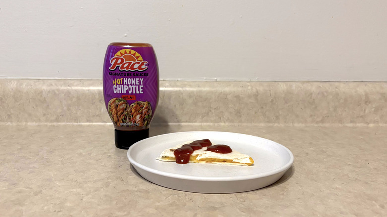 Pace hot honey chipotle sauce on quesadilla on white plate on countertop