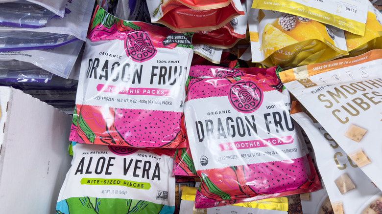 Various frozen fruit smoothie packs in grocery store freezer