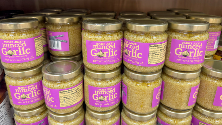 Jars of Trader Joe's minced garlic stacked up on grocery store shelf