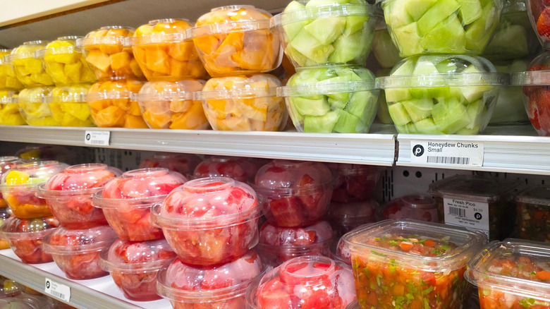 Pre-cut fruit products in plastic tubs on grocery store shelves