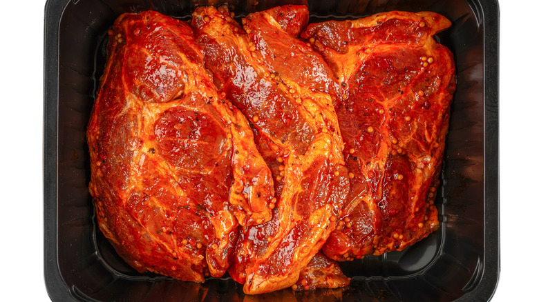 Pre-marinated beef steaks in black plastic packaging