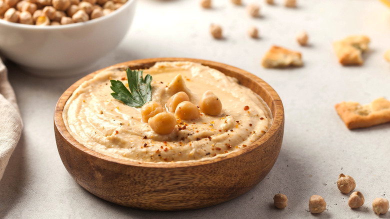 A bowl of hummus topped with chickpeas and herbs