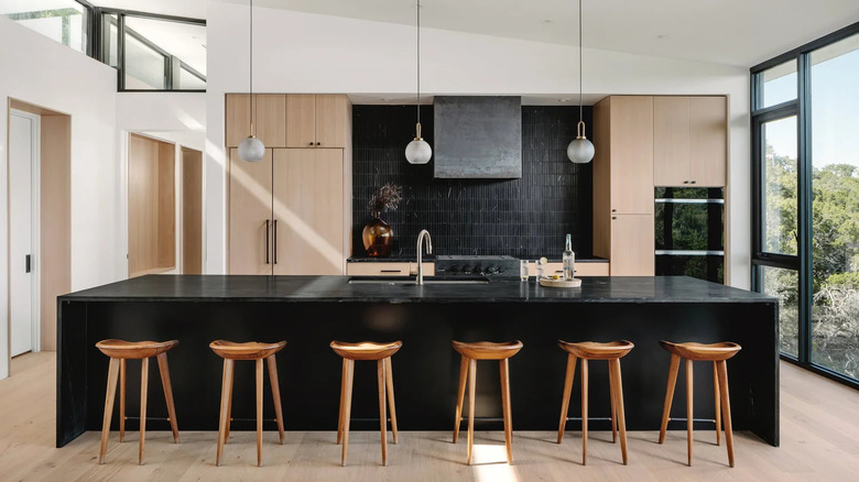 A kitchen with an island and counters of Noire soapstone