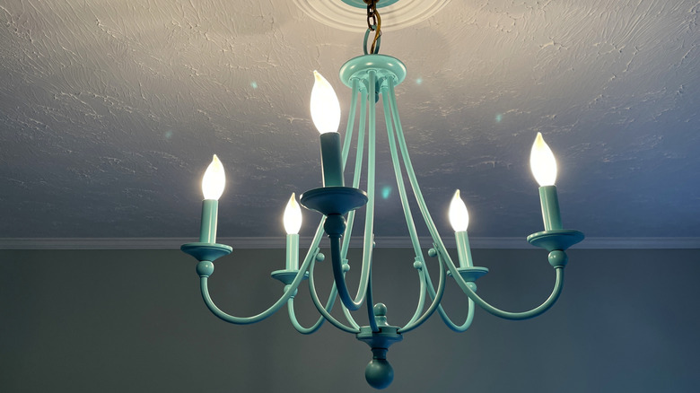 Teal light fixture with 5 bulbs attached to a white ceiling
