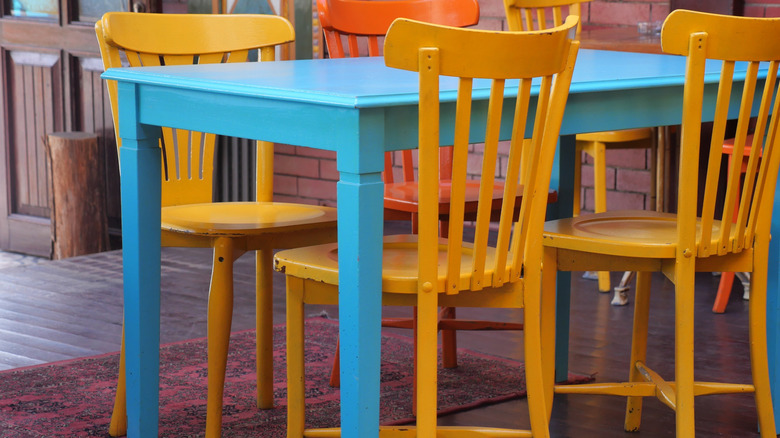 Yellow colored chairs against a blue coloured dining table