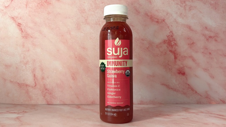 Bottle of Suja Strawberry Guava organic juice on pink background