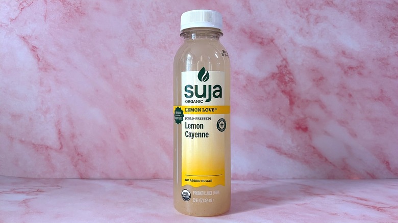 Bottle of Suja Lemon Love organic juice on pink background