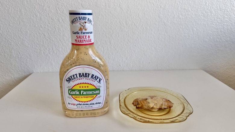 Garlic Parmesan Marinade & Sauce bottle with chicken wing