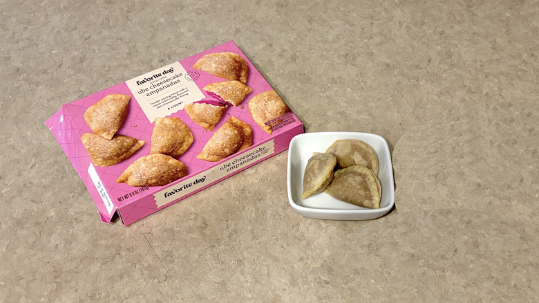 Favorite Day ube cheesecake empanadas in white ramekin and box on neutral background
