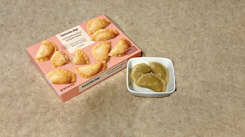 Favorite Day cinnamon bun empanadas in white ramekin and box on neutral background