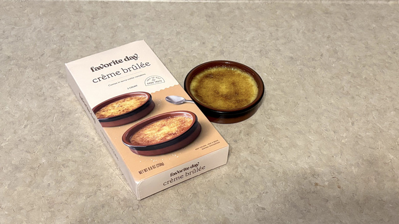 Favorite Day creme brulee in terra-cotta ramekin and box on neutral background