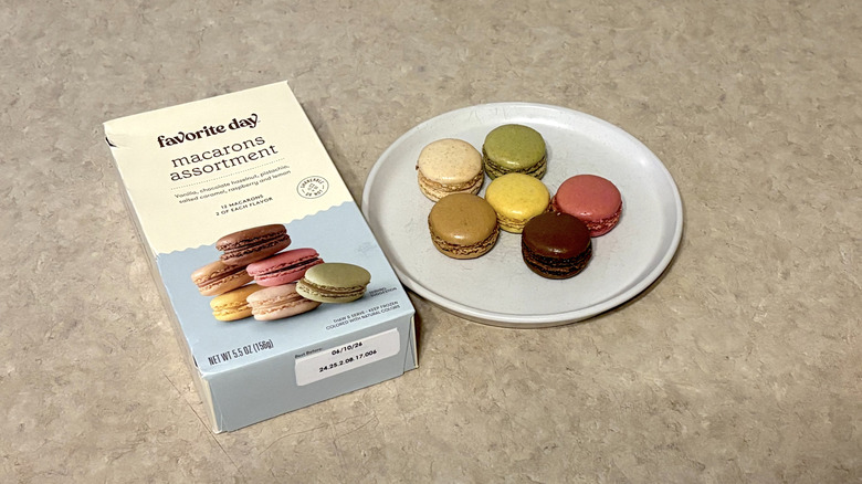 Favorite Day macarons assortment on white plate and box on neutral background