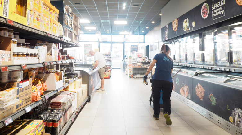 Aldi employee and shopper walking through Aldi aisle