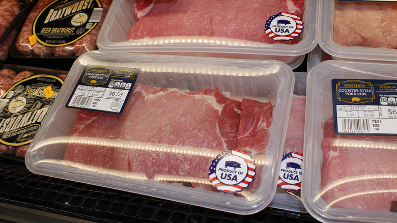 closeup of packets of meat on grocery store shelf