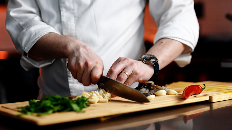 close up of chef chopping ingredients in the kitchen
