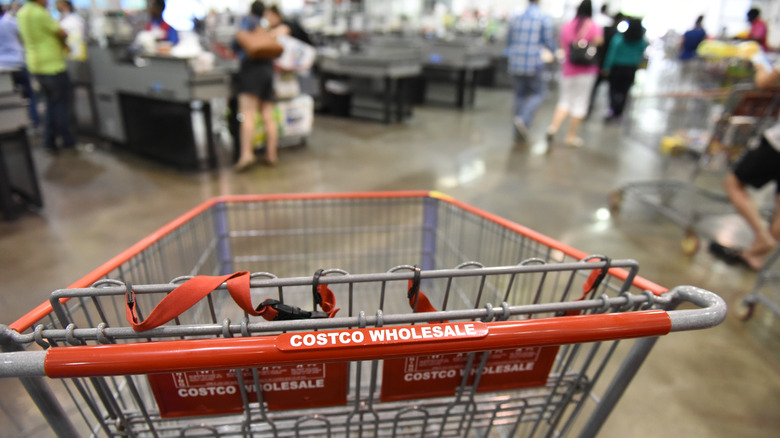 Close-up image of Costco cart with customers and employees in the back