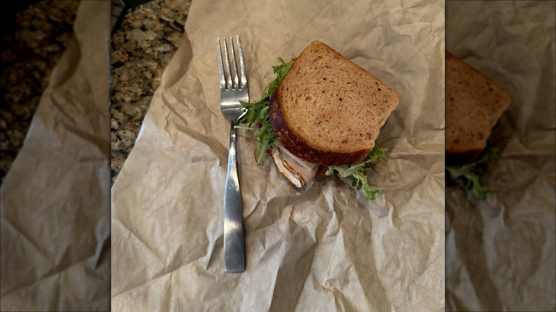 Half sandwich from Panera on brown paper next to a fork