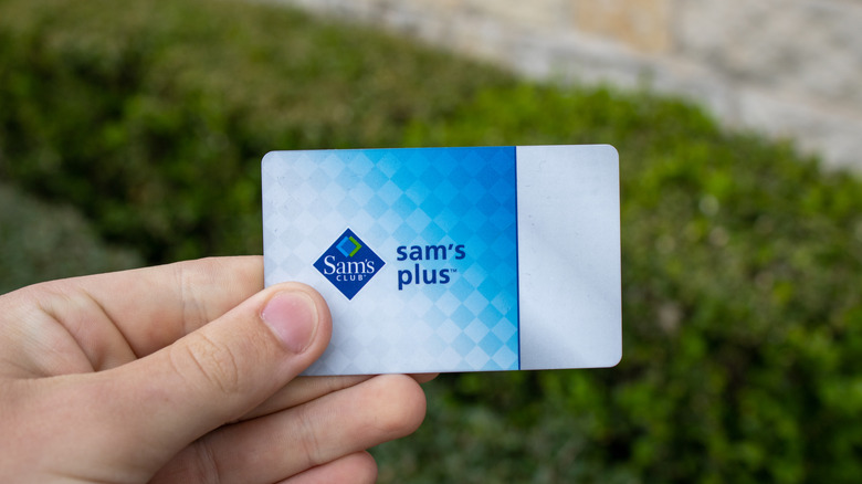 Hand holding Sam's Club Sam's Plus membership card