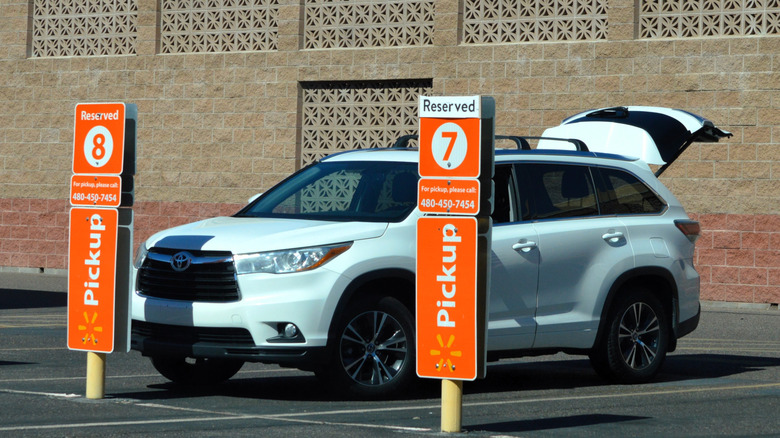 White SUV with trunk open for curbside pickup outside Walmart