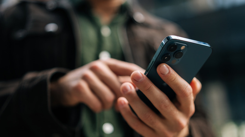 Close-up hands holding and using smartphone