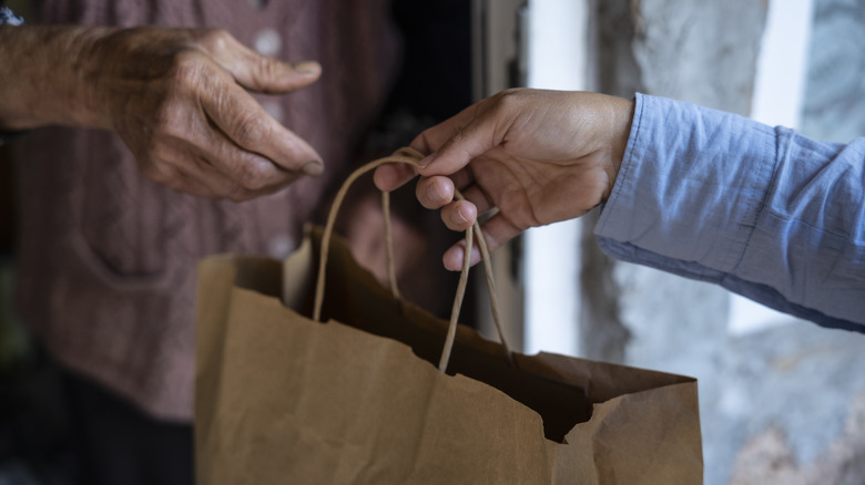 Elderly woman receiving food delivery at the doorway