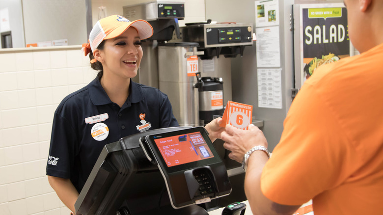 Whataburger employee helping customer with order.