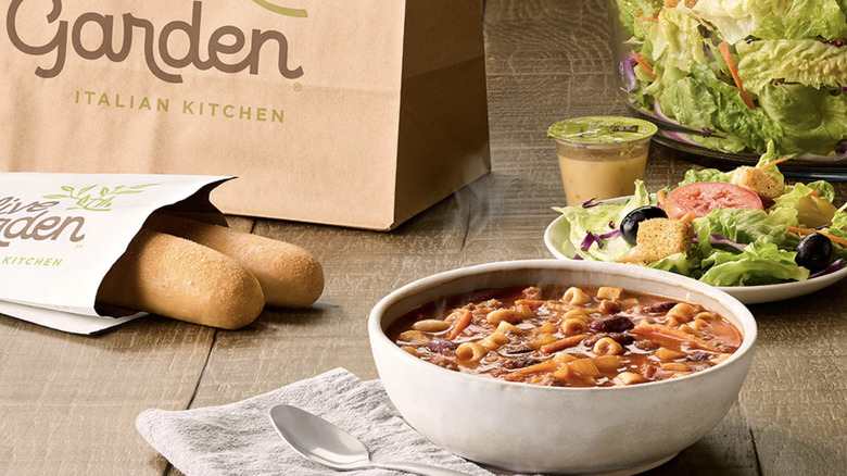 bowl of soup and breadsticks on wood table