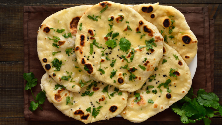 Naan with parsley on wooden board