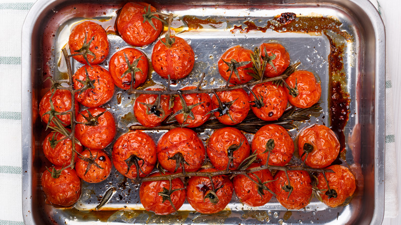 Roasted cherry tomatoes on vine on baking tray
