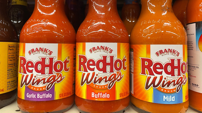 Bottles of Frank's Red Hot sauces on a supermarket shelf