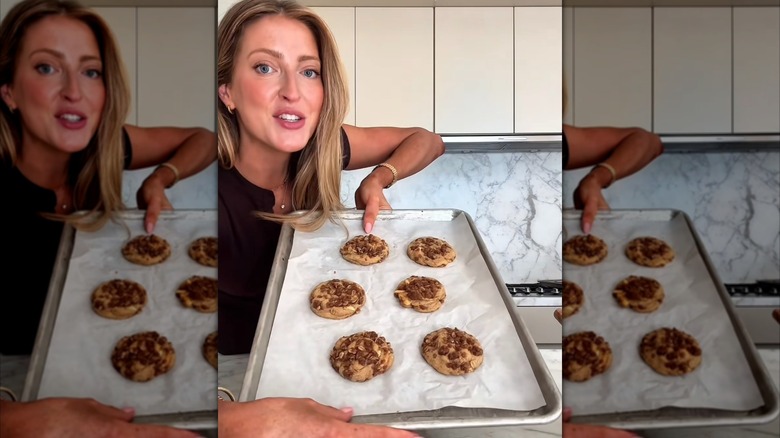 Broma Bakery holding up a tray of fresh cookies
