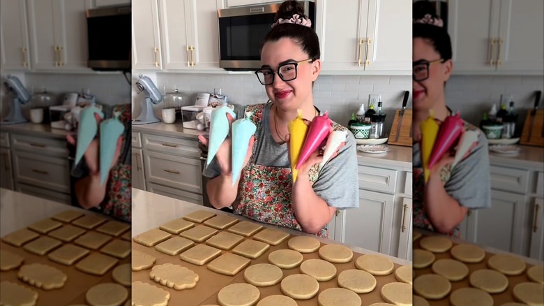 Skylar Toth posing with icing bags and sugar cookies