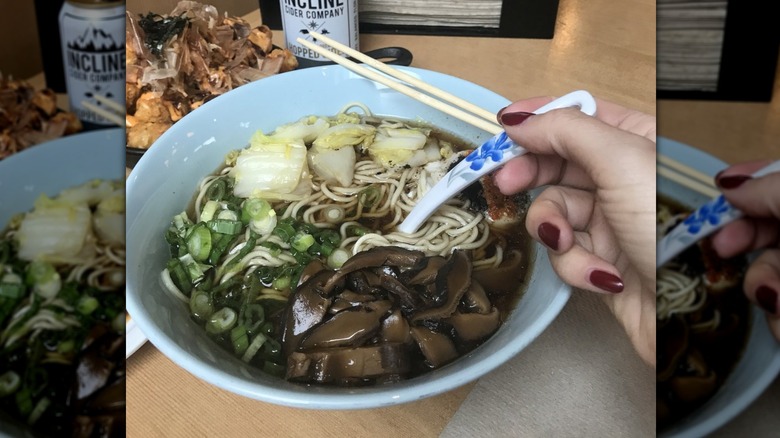 mirrored image of hand and bowl of ramen at Boxer