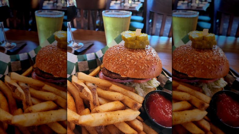 mirrored image of burger and chips with beer in background on restaurant table