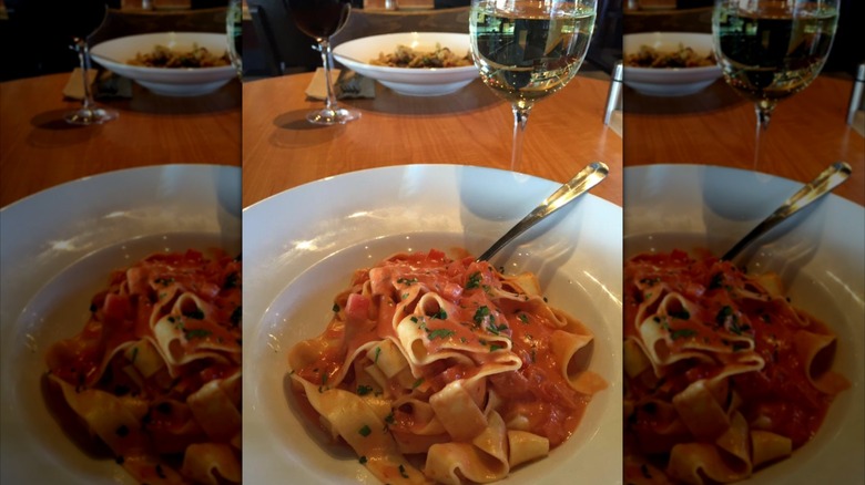 dish of pasta with wine on restaurant table