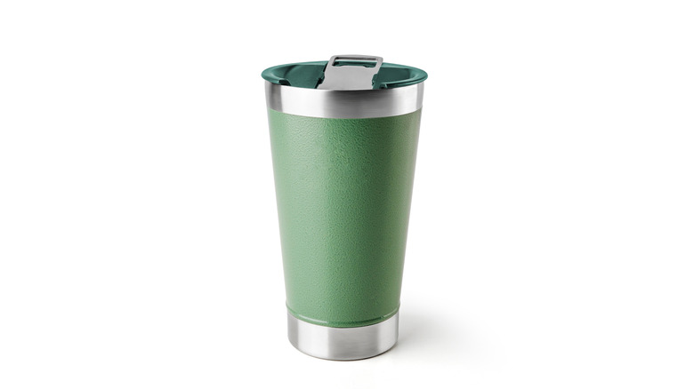 Green vacuum-insulated tumbler on white surface