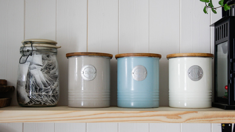 Tea, sugar, and coffee containers lined on a shelf