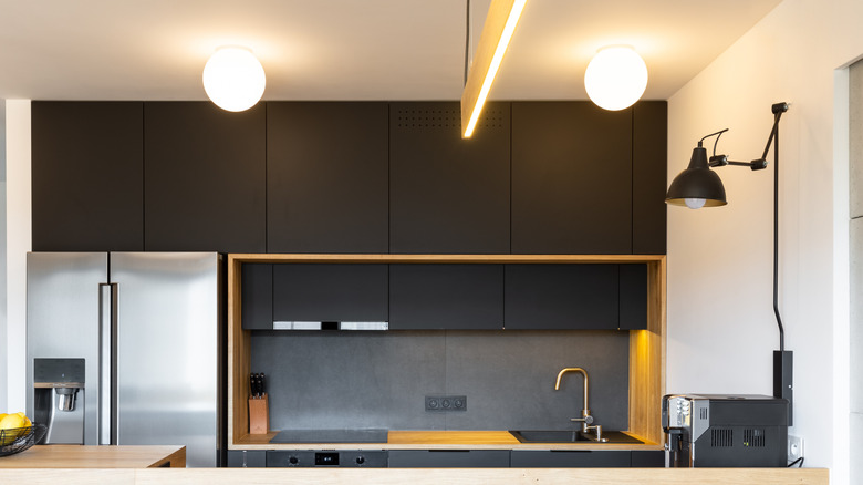 Black furniture and an electric lamp above a coffee machine