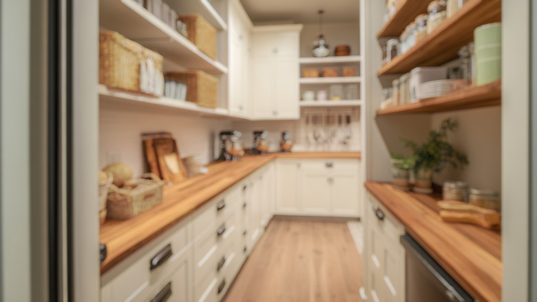 Blurred background image of farmhouse walk-in pantry in cozy colors with wooden countertops