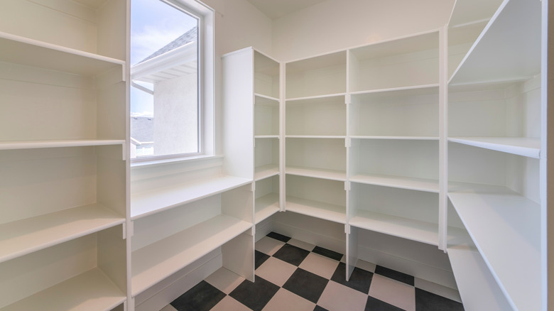 Empty kitchen pantry with tiled flooring