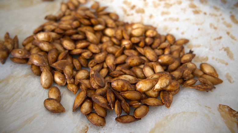 Pile of roasted pumpkin seeds on parchment paper