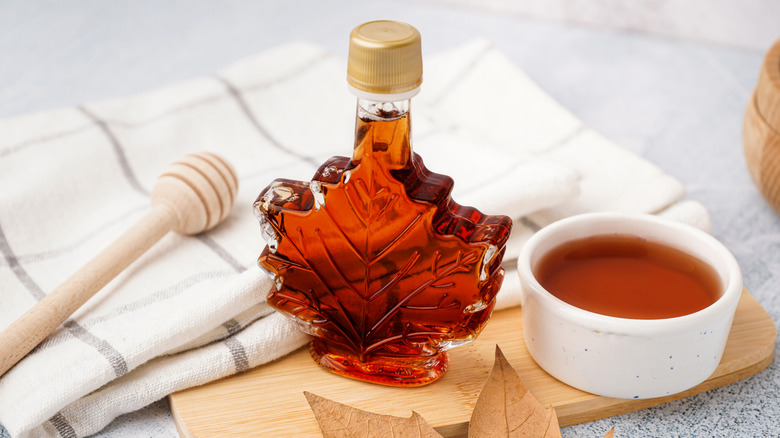 Bowl of maple syrup next to a bottle