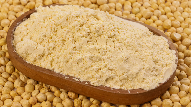 Large bowl of chickpea flour surrounded by chickpeas