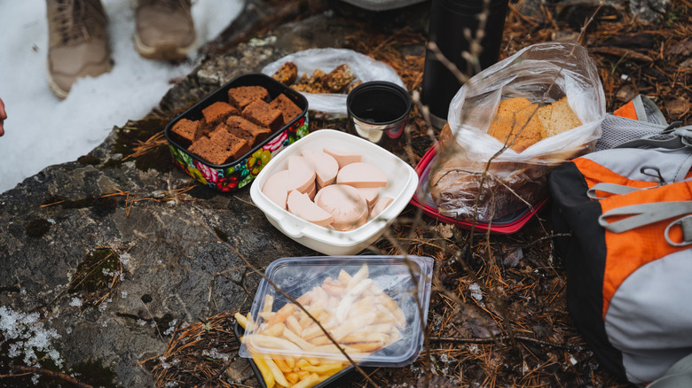 Various foods in reusable containers in the forest during winter