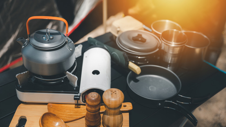 Various compact cooking tools at a campsite