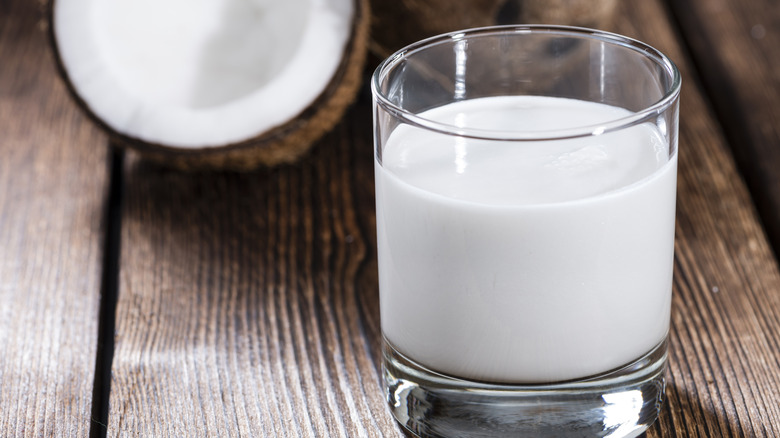 Coconut milk in short glass on wooden table
