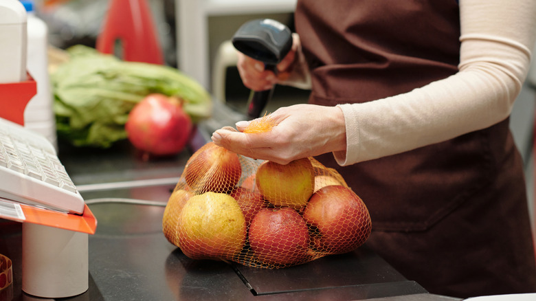 Cashier scanning food to be bagged at grocery store