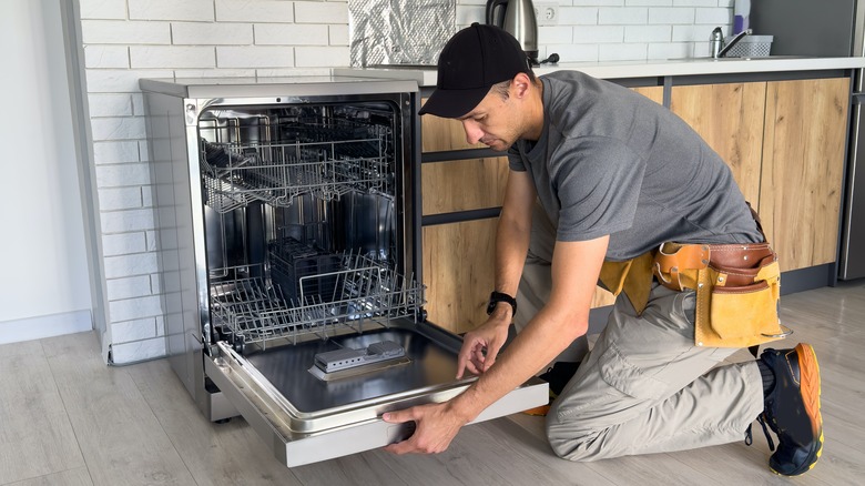 Handyman repairing dishwasher
